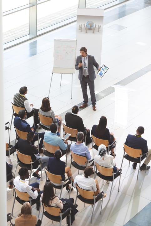 Businessman speaking with digital tablet speaks in a business seminar Businessman speaking with digital tablet speaks in a business seminar